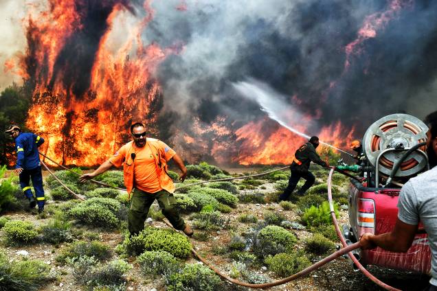 Bombeiros e voluntários trabalham no combate às chamas, durante incêndio florestal no vilarejo de Kineta, próximo de Atenas, Grécia - 24/07/2018 Bombeiros e voluntários trabalham no combate às chamas, durante incêndio florestal no vilarejo de Kineta, próximo de Atenas, Grécia - 24/07/2018