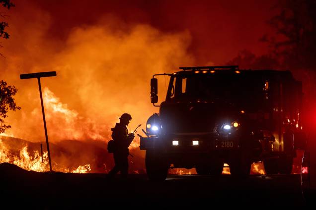 Bombeiro é visto ao lado do caminhão durante o combate ao incêndio florestal Carr, na cidade de Redding, Califórnia - 27/07/2018 Bombeiro é visto ao lado do caminhão durante o combate ao incêndio florestal Carr, na cidade de Redding, Califórnia - 27/07/2018