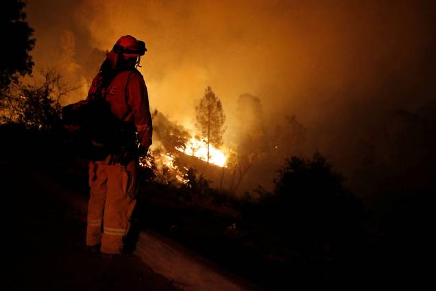Bombeiro observa as chamas enquanto o fogo avança em direção a casas no oeste da cidade de Redding, na Califórnia - 27/07/2018 Bombeiro observa as chamas enquanto o fogo avança em direção a casas no oeste da cidade de Redding, na Califórnia - 27/07/2018