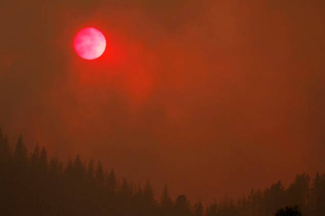O sol fica rosado enquanto a densa fumaça do incêndio florestal Carr sobre das árvores, na Califórnia - 27/07/2018 O sol fica rosado enquanto a densa fumaça do incêndio florestal Carr sobre das árvores, na Califórnia - 27/07/2018