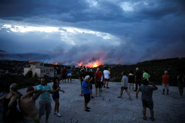 Moradores observam incêndio florestal na cidade de Rafina, perto de Atenas, na Grécia - 23/07/2018 Moradores observam incêndio florestal na cidade de Rafina, perto de Atenas, na Grécia - 23/07/2018