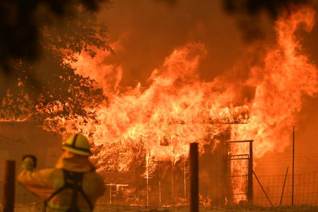 Bombeiro observa enquanto um prédio é consumido pelas chamas do incêndio no Complexo de Mendocino, em Lakeport, na Califórnia - 30/07/2018 Bombeiro observa enquanto um prédio é consumido pelas chamas do incêndio no Complexo de Mendocino, em Lakeport, na Califórnia - 30/07/2018