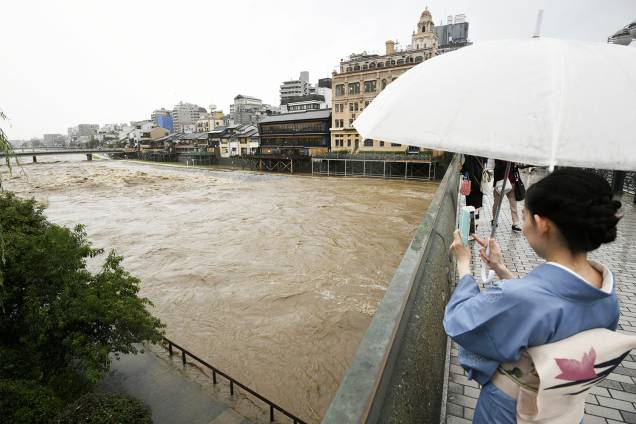 Mulher tira foto de inundação próximo do Rio Kamo, em Kyoto - 05/07/2018 Mulher tira foto de inundação próximo do Rio Kamo, em Kyoto - 05/07/2018