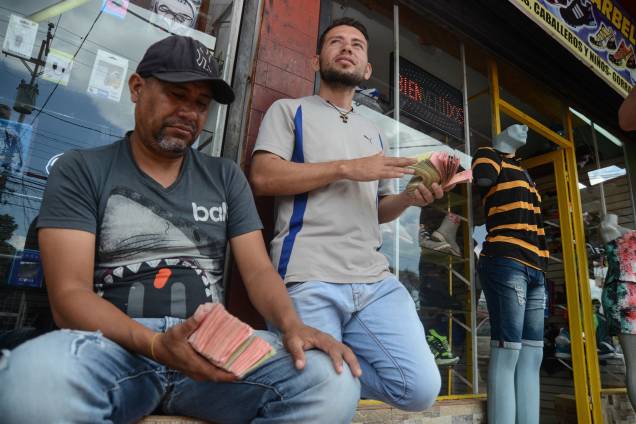 Cambistas exibem maço de dinheiro. 1 real equivale a 300 bolívares Cambistas exibem maço de dinheiro. 1 real equivale a 300 bolívares