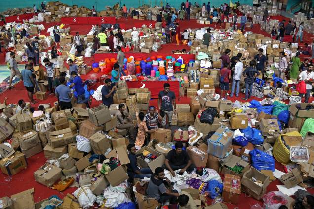 Voluntários trabalham em um centro de distribuição de ajuda dentro de um estádio em Kochi, no sul do estado indiano de Kerala - 19/08/2018 Voluntários trabalham em um centro de distribuição de ajuda dentro de um estádio em Kochi, no sul do estado indiano de Kerala - 19/08/2018