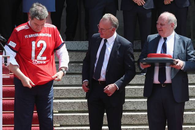 O governador da Baviera, Markus Söder (esq), é visto com camiseta do Bayern de Munique, juntamente com o CEO do clube, Karl-Heinz Rummenigge, e o presidente do Conselho de Administração Uli Hoeness - 09/05/2018 O governador da Baviera, Markus Söder (esq), é visto com camiseta do Bayern de Munique, juntamente com o CEO do clube, Karl-Heinz Rummenigge, e o presidente do Conselho de Administração Uli Hoeness - 09/05/2018