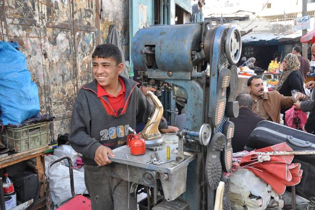 Garoto faz solas de sapato em máquina, na região de Gaza: raro emprego. Garoto faz solas de sapato em máquina, na região de Gaza: raro emprego.