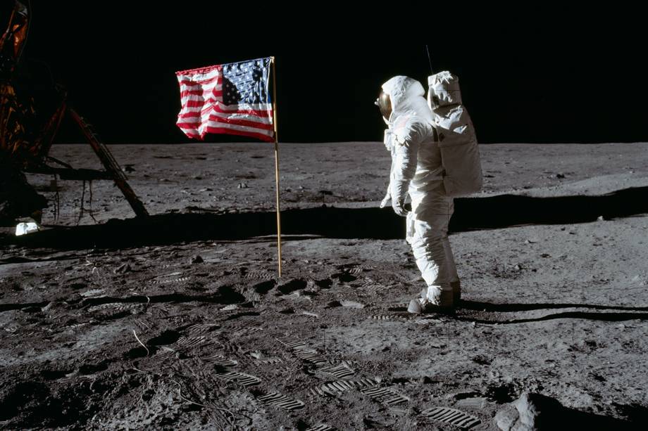 O astronauta Neil Armstrong saudando a bandeira americana após aterrissar em solo lunar O astronauta Neil Armstrong saudando a bandeira americana após aterrissar em solo lunar