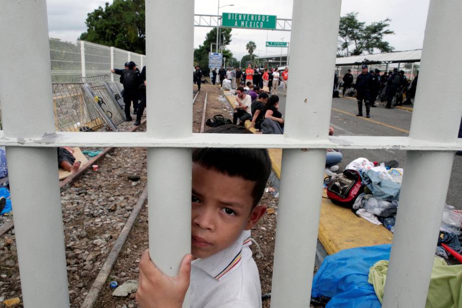 Menino hondurenho, parte de uma caravana que tenta chegar aos Estados Unidos, é fotografado na ponte que liga México e Guatemala em Tecun Uman - 20/10/2018