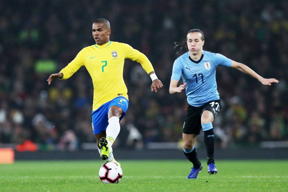 Douglas Costa (esq) disputa bola com Diego Laxalt (dir), durante amistoso entre Brasil e Uruguai, realizado no Emirates Stadium, em Londres - 16/11/2018 Douglas Costa (esq) disputa bola com Diego Laxalt (dir), durante amistoso entre Brasil e Uruguai, realizado no Emirates Stadium, em Londres - 16/11/2018