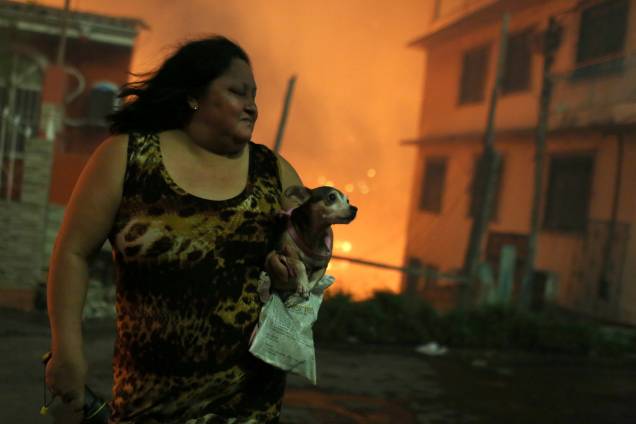 Mulher carrega seu cachorro após deixar sua casa durante incêndio de grandes proporções no bairro de Educandos, zona sul de Manaus - 17/12/2018 Mulher carrega seu cachorro após deixar sua casa durante incêndio de grandes proporções no bairro de Educandos, zona sul de Manaus - 17/12/2018