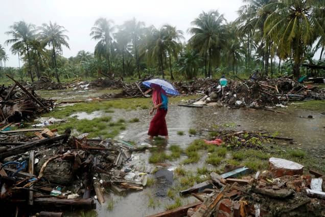 Mulher caminha pelos escombros causados pelo tsunami que atingiu a Indonésia, na cidade de Sumur - 26/12/2018 Mulher caminha pelos escombros causados pelo tsunami que atingiu a Indonésia, na cidade de Sumur - 26/12/2018