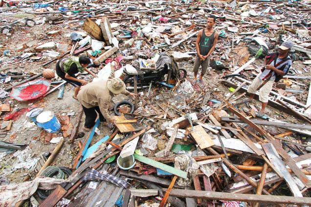 Moradores locais procuram pertences entre destroços após forte tsunami atingir a praia de Tanjung Lesung, localizada na província de Banten - 24/12/2018 Moradores locais procuram pertences entre destroços após forte tsunami atingir a praia de Tanjung Lesung, localizada na província de Banten - 24/12/2018