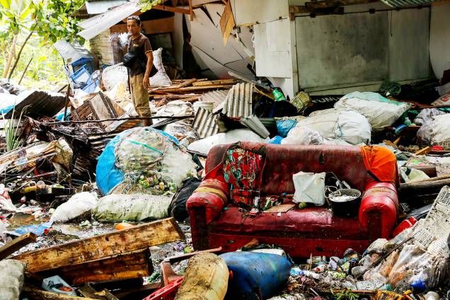Homem observa destroços após forte tsunami atingir a regência de Pandeglang, localizada na província de Banten, na Indonésia - 24/12/2018 Homem observa destroços após forte tsunami atingir a regência de Pandeglang, localizada na província de Banten, na Indonésia - 24/12/2018