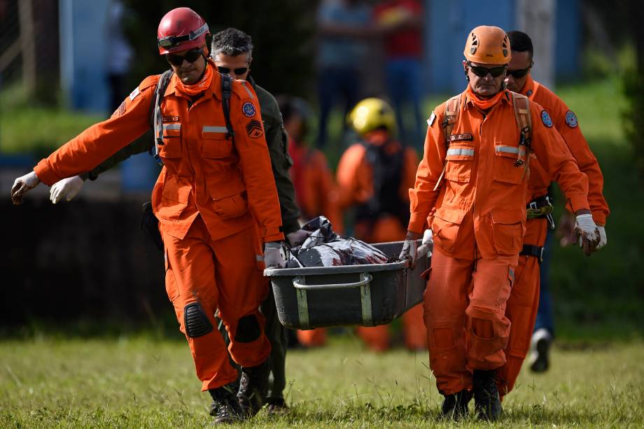 Bombeiros carregam o corpo de uma vítima retirada da lama um dia após o colapso da barragem de uma mina de minério de ferro pertencente à Vale, em Brumadinho (MG) - 26/01/2019