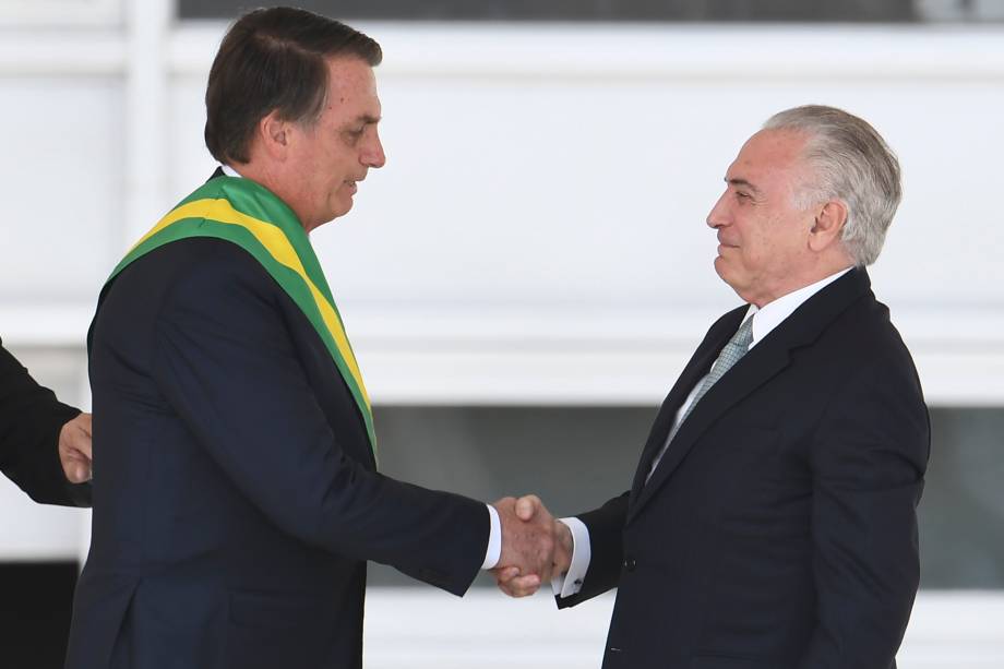 Presidente Jair Bolsonaro recebe a faixa presidencial do ex-presidente Michel Temer após subir a rampa do Palácio do Planalto, em Brasília - 01/01/2019