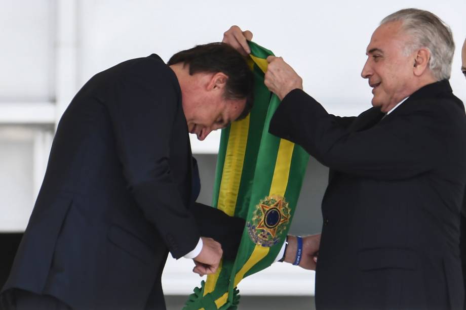 Presidente Jair Bolsonaro recebe a faixa presidencial do ex-presidente Michel Temer após subir a rampa do Palácio do Planalto, em Brasília - 01/01/2019 Presidente Jair Bolsonaro recebe a faixa presidencial do ex-presidente Michel Temer após subir a rampa do Palácio do Planalto, em Brasília - 01/01/2019