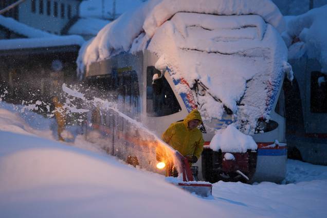 Trabalhador remove a neve ao lado de um trem regional na estação de Berchtesgaden, na Alemanha - 10/01/2019 Trabalhador remove a neve ao lado de um trem regional na estação de Berchtesgaden, na Alemanha - 10/01/2019