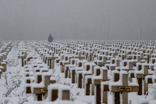 Homem caminha entre túmulos cobertos de neve no Cemitério Militar de Notre-dame de Lorette em Souchez, França - 23/01/2019 Homem caminha entre túmulos cobertos de neve no Cemitério Militar de Notre-dame de Lorette em Souchez, França - 23/01/2019