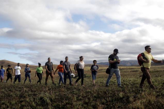 Pessoas andando em fila tentam atravessar a fronteira fechada entre Brasil e Venezuela em Pacaraima, estado de Roraima - 22/02/2019 Pessoas andando em fila tentam atravessar a fronteira fechada entre Brasil e Venezuela em Pacaraima, estado de Roraima - 22/02/2019