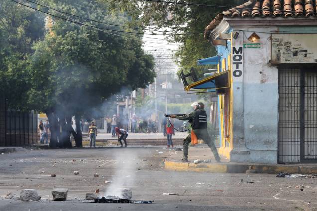 Membro da força de segurança da Venezuela aponta sua espingarda durante confronto com os manifestantes em Ureña, Venezuela - 23/02/2019 Membro da força de segurança da Venezuela aponta sua espingarda durante confronto com os manifestantes em Ureña, Venezuela - 23/02/2019