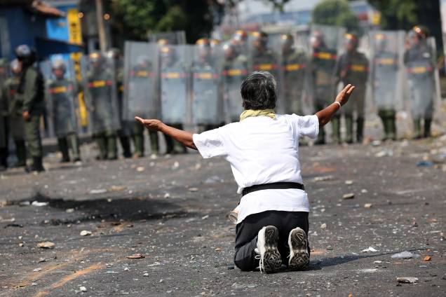 Manifestante ajoelha em frente a força de segurança em Ureña, Venezuela - 23/02/2019 Manifestante ajoelha em frente a força de segurança em Ureña, Venezuela - 23/02/2019