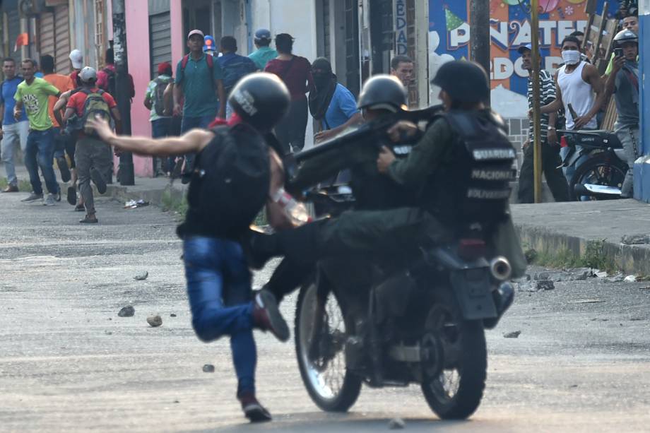 Membros da guarda nacional derrubam manifestante durante protesto em Ureña, Venezuela - 23/02/2019 Membros da guarda nacional derrubam manifestante durante protesto em Ureña, Venezuela - 23/02/2019