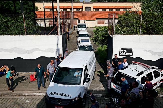 Carros funerários retiram corpos da E.E Raul Brasil