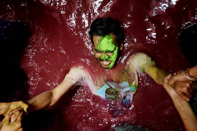 Um folião se diverte durante o festival hindu Holi mergulhado em tinta na cidade de Chennai, na Índia - 21/03/2019 Um folião se diverte durante o festival hindu Holi mergulhado em tinta na cidade de Chennai, na Índia - 21/03/2019