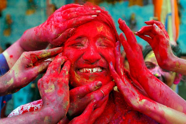 Uma mulher têm seu rosto colorido com um pó vermelho durante o festival Holi, em Calcutá, na Índia - 21/03/2019 Uma mulher têm seu rosto colorido com um pó vermelho durante o festival Holi, em Calcutá, na Índia - 21/03/2019