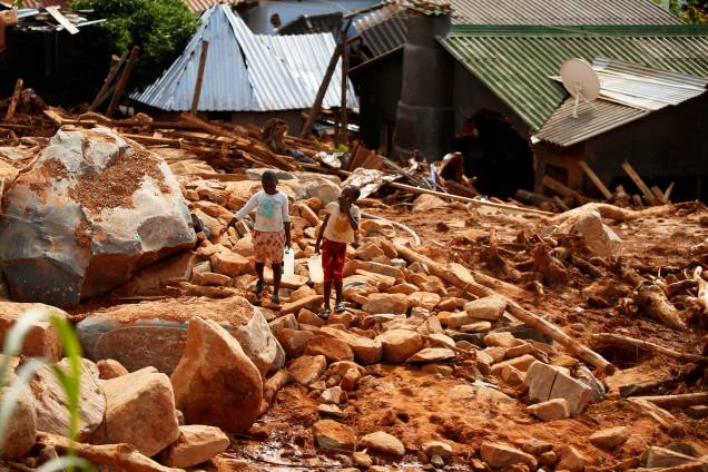 Crianças carregam galões de água entre escombros, após a passagem do ciclone Idai, na região de Chimanimani, fronteira entre o Moçambique e o Zimbábue - 22/03/2019 Crianças carregam galões de água entre escombros, após a passagem do ciclone Idai, na região de Chimanimani, fronteira entre o Moçambique e o Zimbábue - 22/03/2019