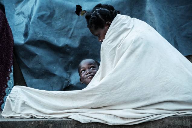 Maria Armando, 30, e seu filho Fernando Emmanuel, 5, se abrigam sob uma arquibancada em Buzi, Moçambique - 23/03/2019 Maria Armando, 30, e seu filho Fernando Emmanuel, 5, se abrigam sob uma arquibancada em Buzi, Moçambique - 23/03/2019