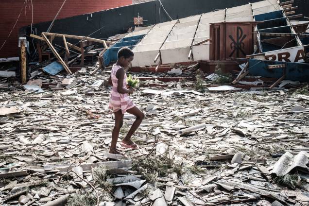 Menina recolhe flores artificiais dos escombros de um edifício destruído pelo ciclone Idai na Igreja Católica do Sagrado Coração, em Beira, Moçambique - 24/03/2019 Menina recolhe flores artificiais dos escombros de um edifício destruído pelo ciclone Idai na Igreja Católica do Sagrado Coração, em Beira, Moçambique - 24/03/2019
