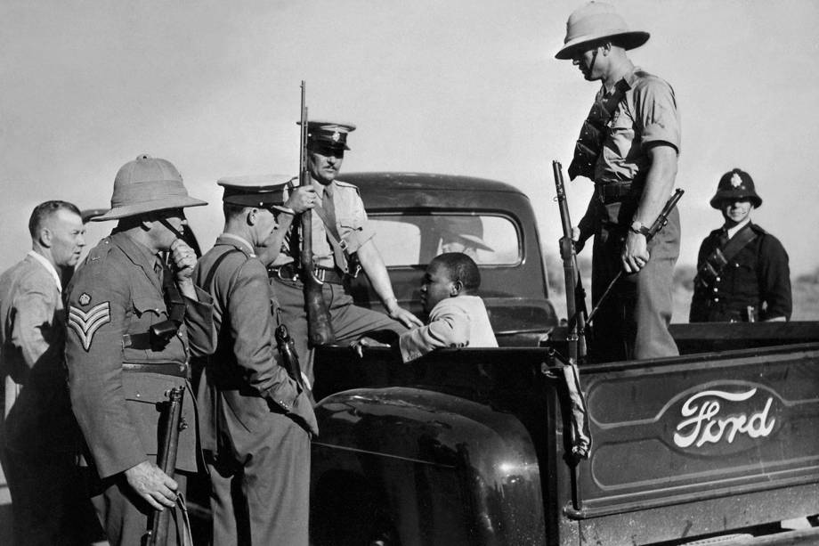 Homem negro é detido por policiais na cidade de East London, localizada na África do Sul - 01/10/1952 Homem negro é detido por policiais na cidade de East London, localizada na África do Sul - 01/10/1952