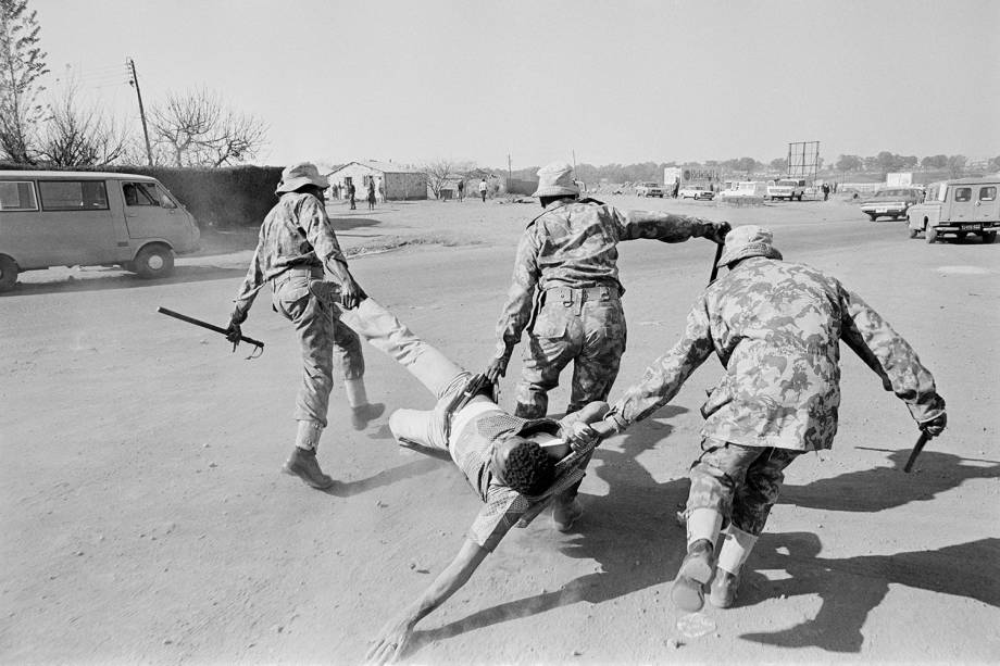 Policiais carregam manifestante anti-apartheid, durante protesto realizado em Soweto, na África do Sul - 15/06/1980 Policiais carregam manifestante anti-apartheid, durante protesto realizado em Soweto, na África do Sul - 15/06/1980