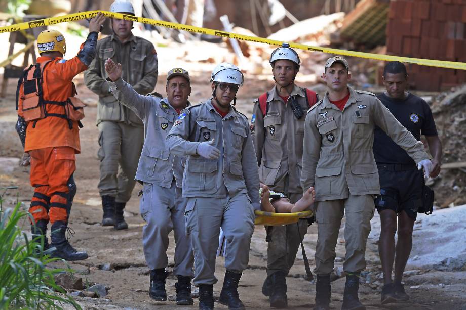 Equipes de resgate carregam uma pessoa ferida depois que dois prédios desabaram na comunidade da Muzema, Rio de Janeiro - 12/04/2019 Equipes de resgate carregam uma pessoa ferida depois que dois prédios desabaram na comunidade da Muzema, Rio de Janeiro - 12/04/2019