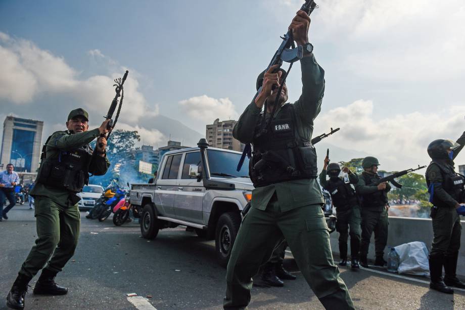 Membros da Guarda Nacional Bolivariana que se juntaram ao líder de oposição venezuelana e autoproclamado presidente em exercício Juan Guaidó disparam para o ar para repelir as forças leais ao presidente Nicolás Maduro perto da base militar de 'La Carlota' em Caracas - 30/04/2019