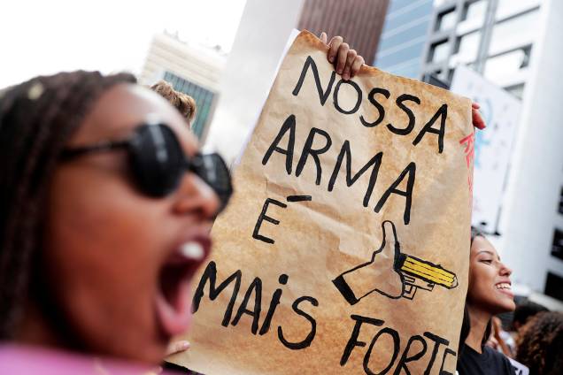 Cartaz em protesto em São Paulo faz referência à bandeira do governo Bolsonaro de defesa das armas (SP) - 15/05/2019 Cartaz em protesto em São Paulo faz referência à bandeira do governo Bolsonaro de defesa das armas (SP) - 15/05/2019