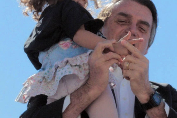 O então pré-candidato do PSL à Presidência da República, Jair Bolsonaro, aparece em um vídeo ensinando uma menina a fazer um gesto de arma com a mão