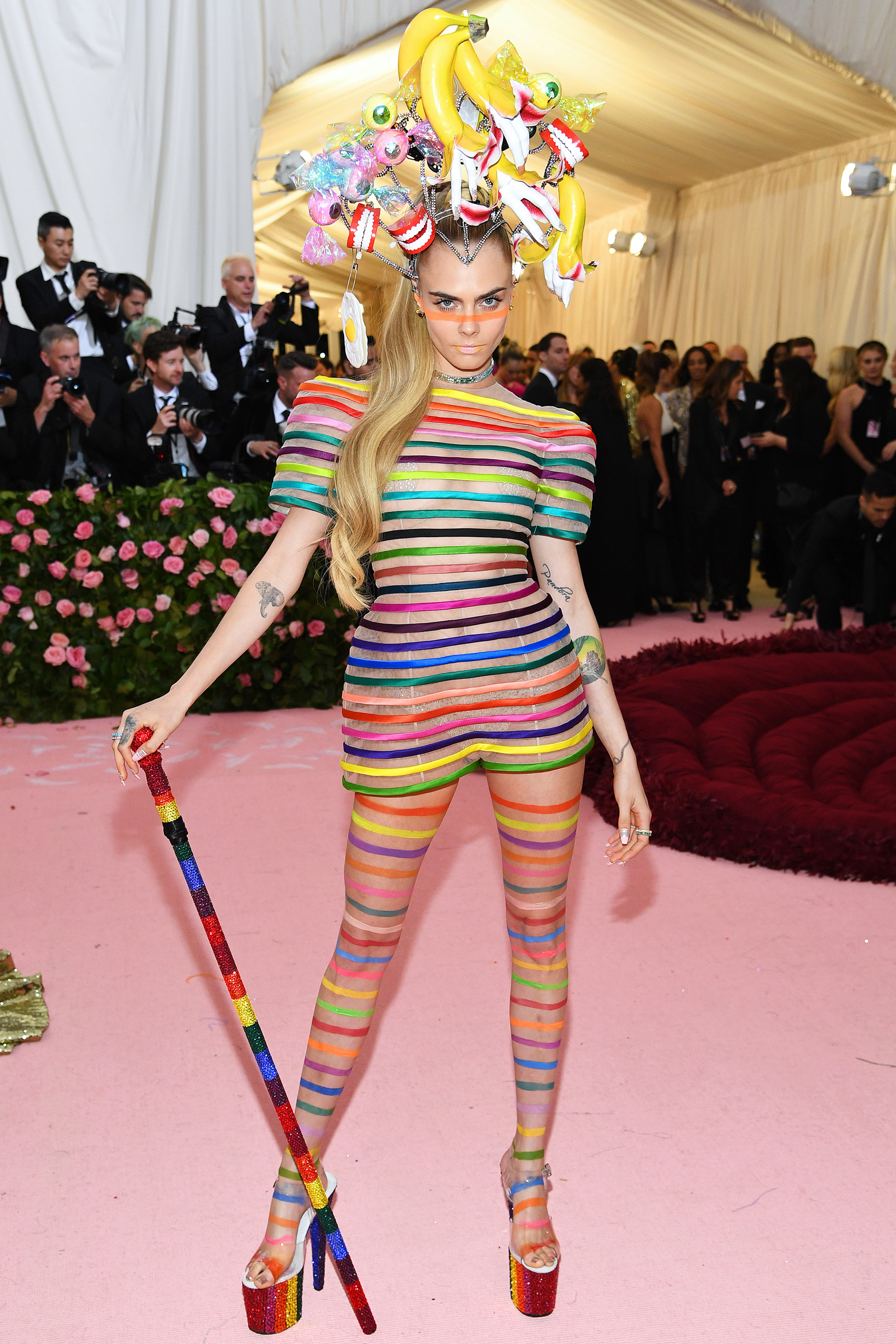 Cara Delevingne apostou no l&uacute;dico com visual colorido, com dentaduras e bananas na cabe&ccedil;a