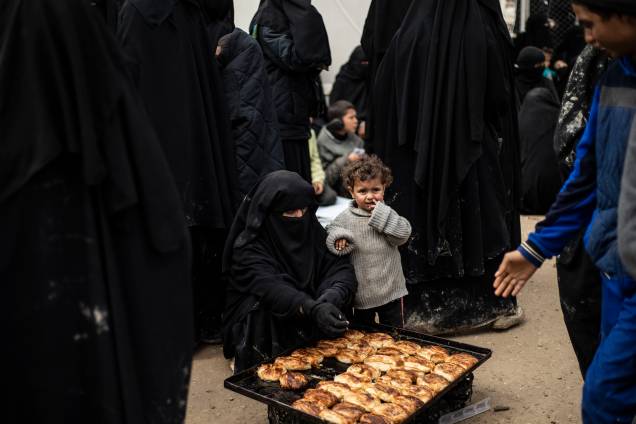 Mulher e criança aguardam a vez para comerem pão no no campo de Al-Hol, que abriga membros do autoproclamado Estado Islâmico (ISIS), no nordeste da Síria Mulher e criança aguardam a vez para comerem pão no no campo de Al-Hol, que abriga membros do autoproclamado Estado Islâmico (ISIS), no nordeste da Síria