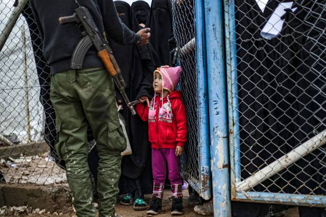 Menina olha para membro das Forças Democráticas da Síria (SDF) no campo de al-Hol, que abriga parentes de membros do grupo Estado Islâmico (IS), na província de al-Hasakeh, nordeste da Síria - 28/03/2019 Menina olha para membro das Forças Democráticas da Síria (SDF) no campo de al-Hol, que abriga parentes de membros do grupo Estado Islâmico (IS), na província de al-Hasakeh, nordeste da Síria - 28/03/2019