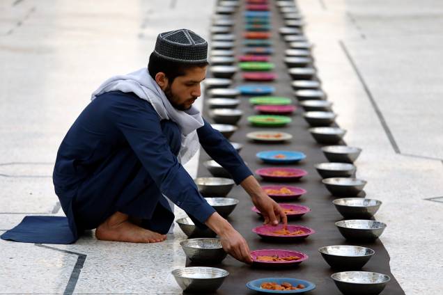 Homem organiza pratos de comida antes de quebrar o jejum durante o mês do Ramadã em Peshawar, Paquistão - 06/05/2019 Homem organiza pratos de comida antes de quebrar o jejum durante o mês do Ramadã em Peshawar, Paquistão - 06/05/2019