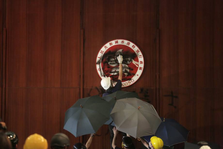 Manifestante picha emblema de Hong Kong durante invasão no prédio do Conselho Legislativo do país, em Hong Kong - 01/07/2019