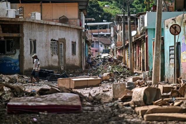 Um morador local caminha entre escombros após o transbordamento do córrego Da Prata devido a chuvas torrenciais, em Raposos, região metropolitana de Belo Horizonte, em 28 de janeiro Um morador local caminha entre escombros após o transbordamento do córrego Da Prata devido a chuvas torrenciais, em Raposos, região metropolitana de Belo Horizonte, em 28 de janeiro