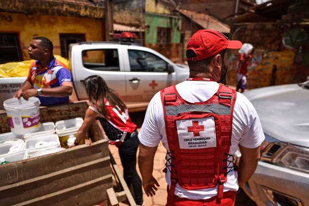 Membros da Cruz Vermelha do Brasil distribuem água e material de limpeza para os moradores locais, após o transbordamento do córrego Da Prata devido a chuvas torrenciais, em Raposos, região metropolitana de Belo Horizonte, em 28 de janeiro Membros da Cruz Vermelha do Brasil distribuem água e material de limpeza para os moradores locais, após o transbordamento do córrego Da Prata devido a chuvas torrenciais, em Raposos, região metropolitana de Belo Horizonte, em 28 de janeiro
