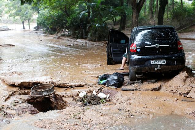 Carro e rua danificados são retratados após fortes inundações causadas por chuvas em Belo Horizonte, 29 de janeiro Carro e rua danificados são retratados após fortes inundações causadas por chuvas em Belo Horizonte, 29 de janeiro