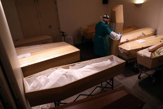 Preparação: Agente funerário usando traje de proteção segura a tampa de um esquife em Bruxelas, na Bélgica Preparação: Agente funerário usando traje de proteção segura a tampa de um esquife em Bruxelas, na Bélgica