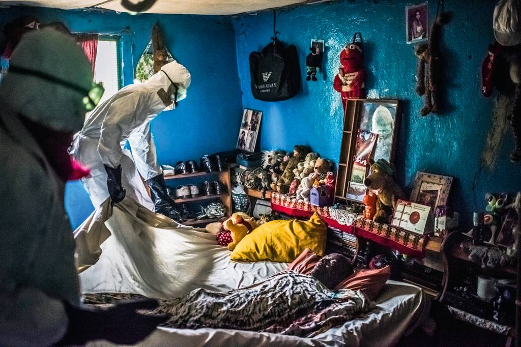 EBOLA OUTBREAK Homem com roupa de proteção retira um corpo de alguém vitima do ebola