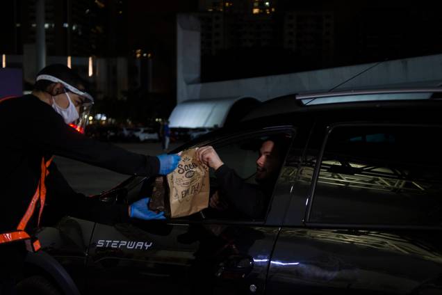 Primeiro, passam por um stand e sem sair do carro recebem o seu "kit alimentação" Primeiro, passam por um stand e sem sair do carro recebem o seu "kit alimentação"